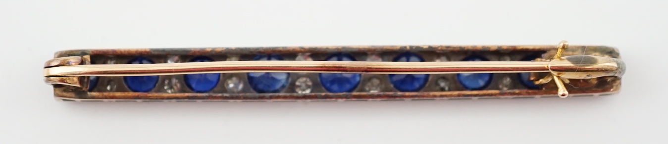 An Edwardian gold and graduated nine stone round cut sapphire set bar brooch